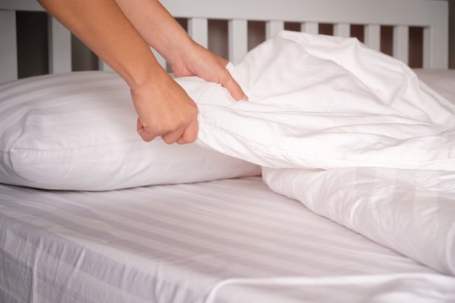 Closeup of hands making bed