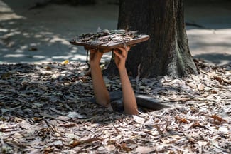 turista na entrada dos túneis Cu Chi no Vietnã