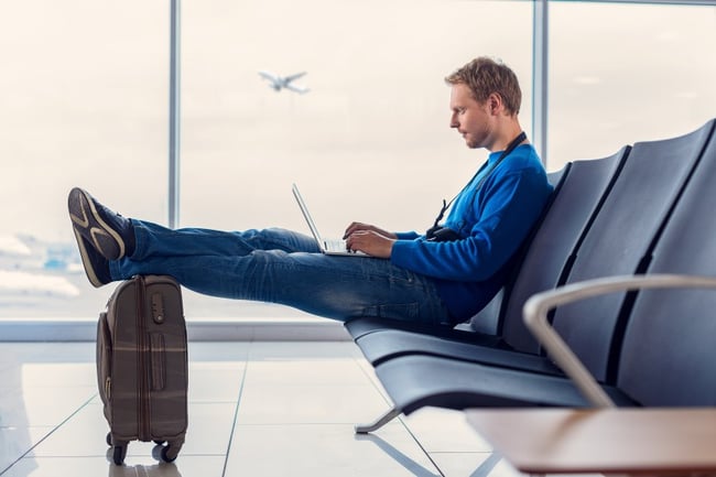 Young man waiting for his flight at the airport